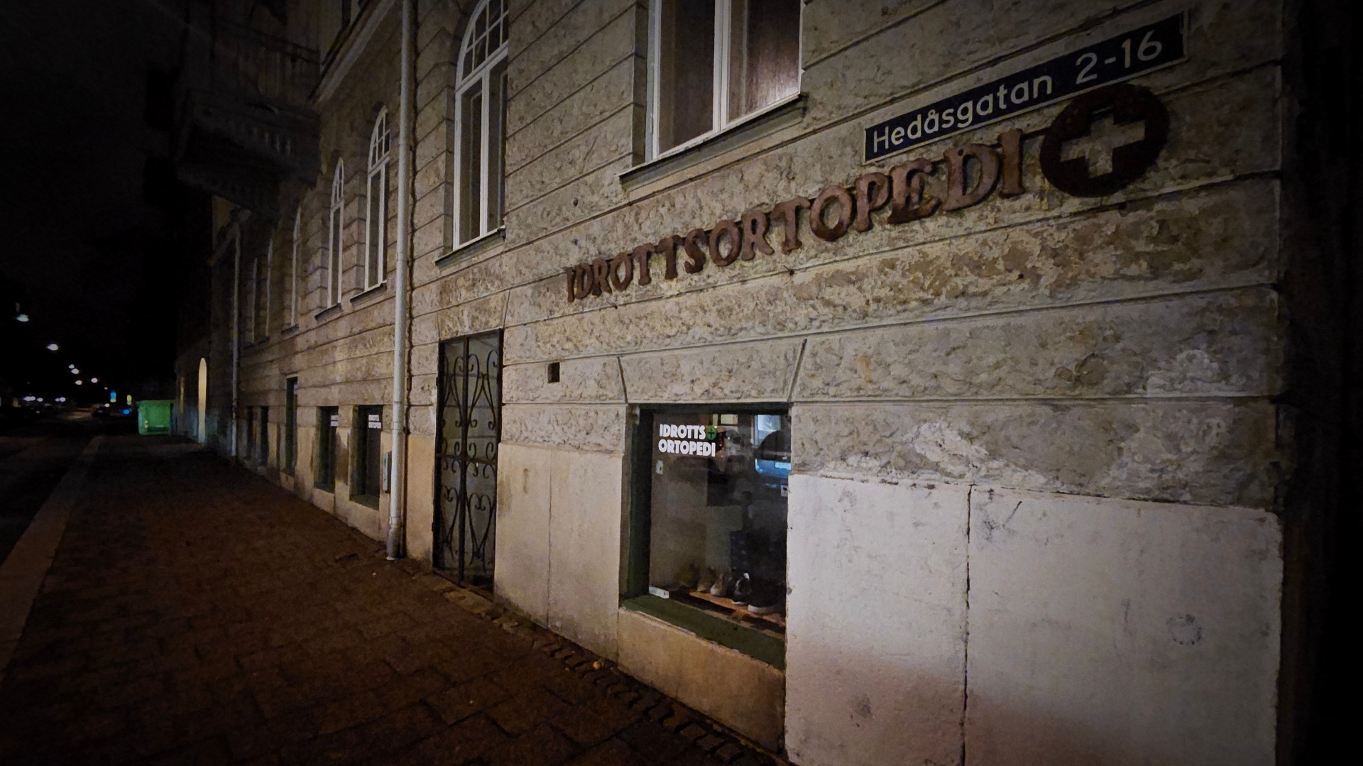 Idrottsortopedis fasad vid Hedåsgatan i Göteborg, kvällsljus över stenfasaden och skyltfönstret.