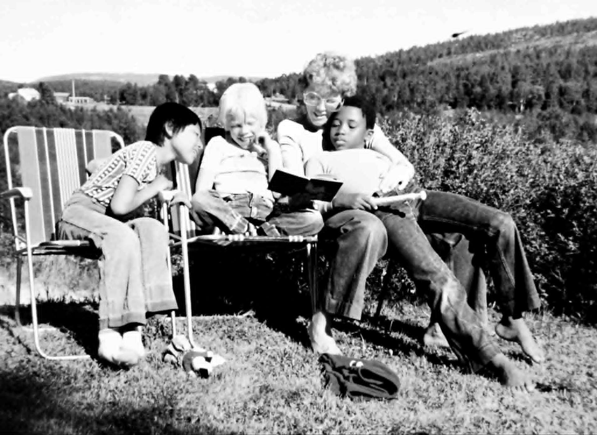 Svartvit barndomsbild med Marianne och barn i sommarlandskap